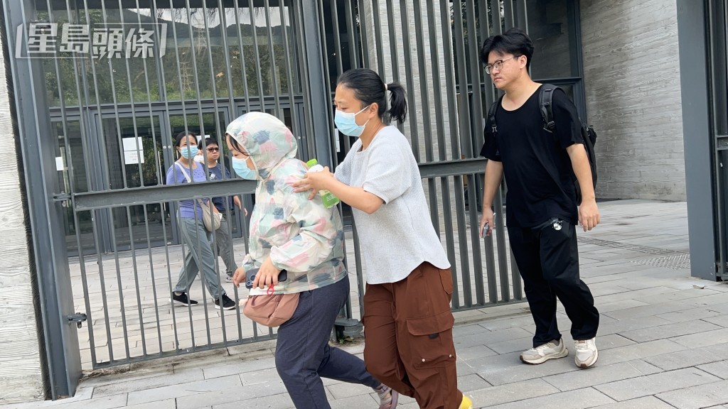 死者的女兒（左）傷心欲絕，需由其他親屬攙扶離開。
