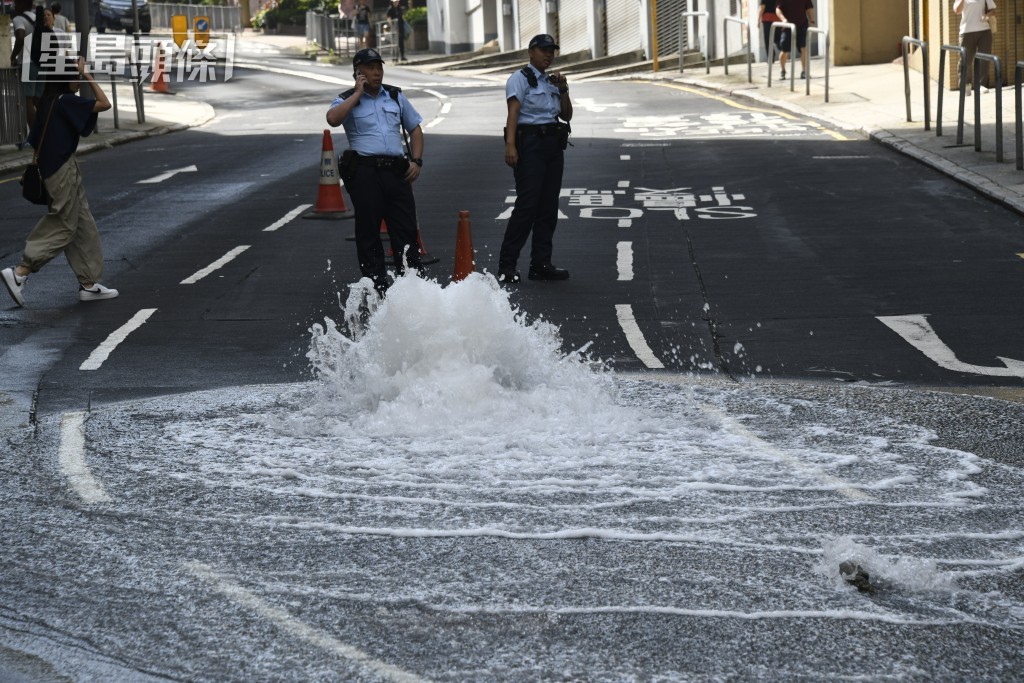 炮台山道爆地底鹹水管，警員到場處理。楊偉亨攝