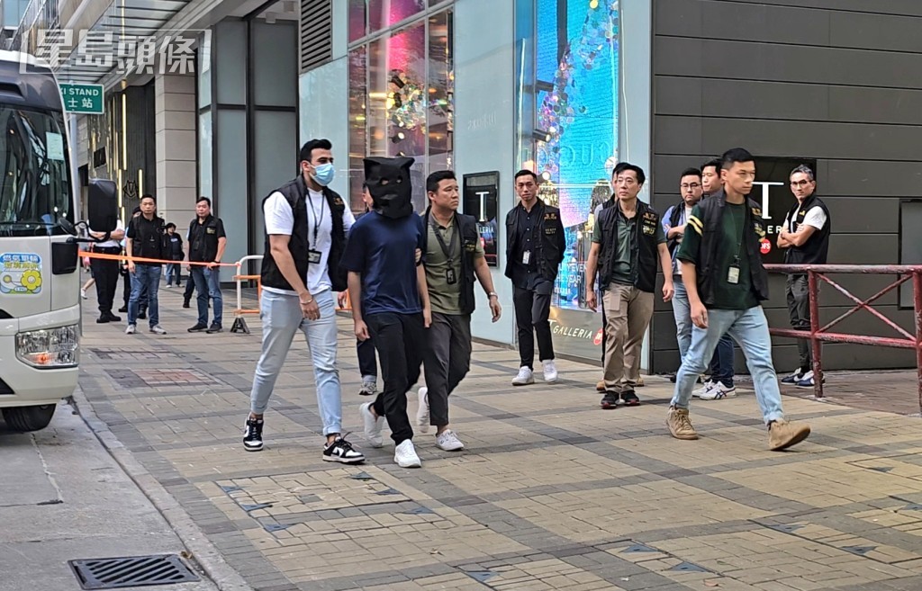 警方押解疑犯返回現場重組案情。