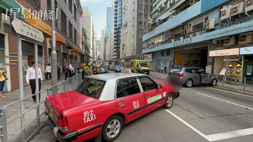 寶馬與貨車相撞後，剷上行人路撞傷一對男女途人，再撼的士。林思明攝