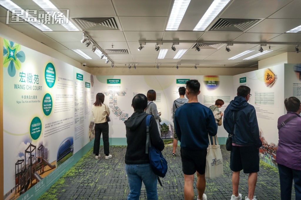 大批中籤人士圍在屏幕前，觀看各單位的出售情況。