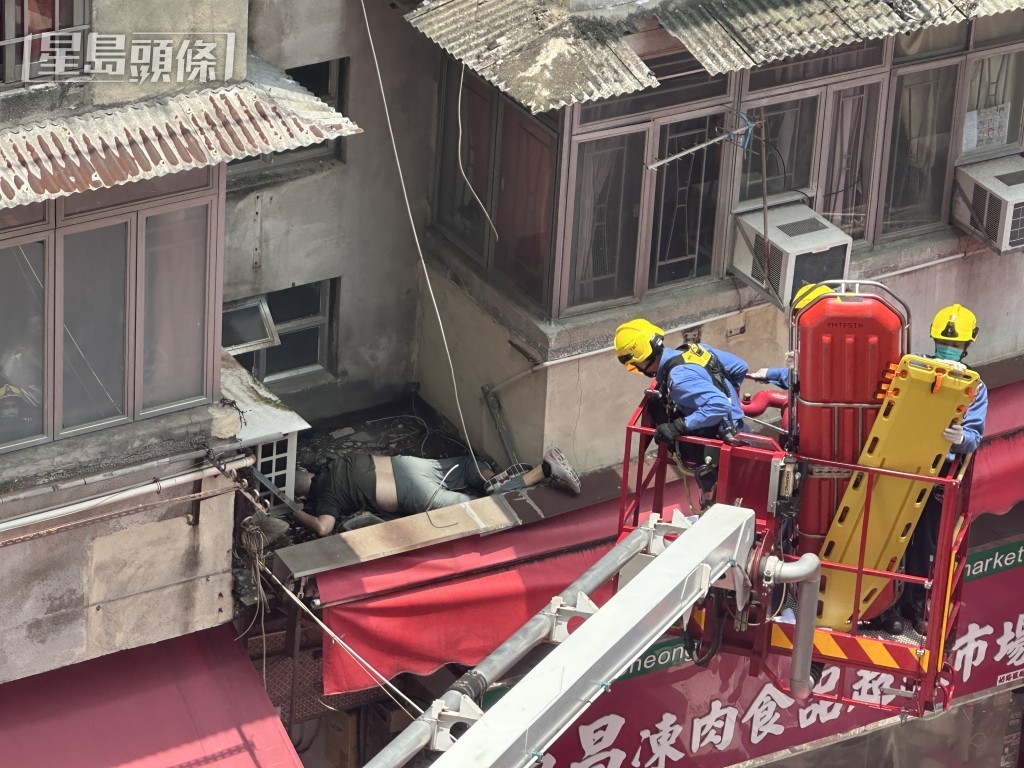 男子倒臥於兩個單位外牆之間的狹小簷篷上。 男子倒臥於兩個單位外牆之間的狹小簷篷上。