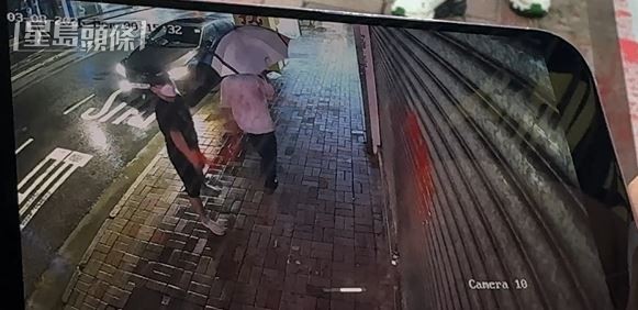 黑衫男向找換店鐵閘淋潑紅油。 黑衫男向找換店鐵閘淋潑紅油。