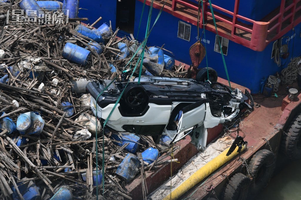 白色私家車被撈起吊上躉船。梁國峰攝