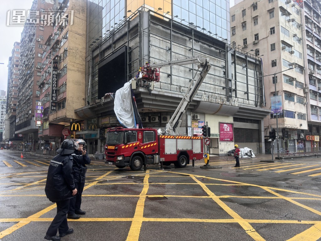 消防升起雲梯拆除塌下的海報。