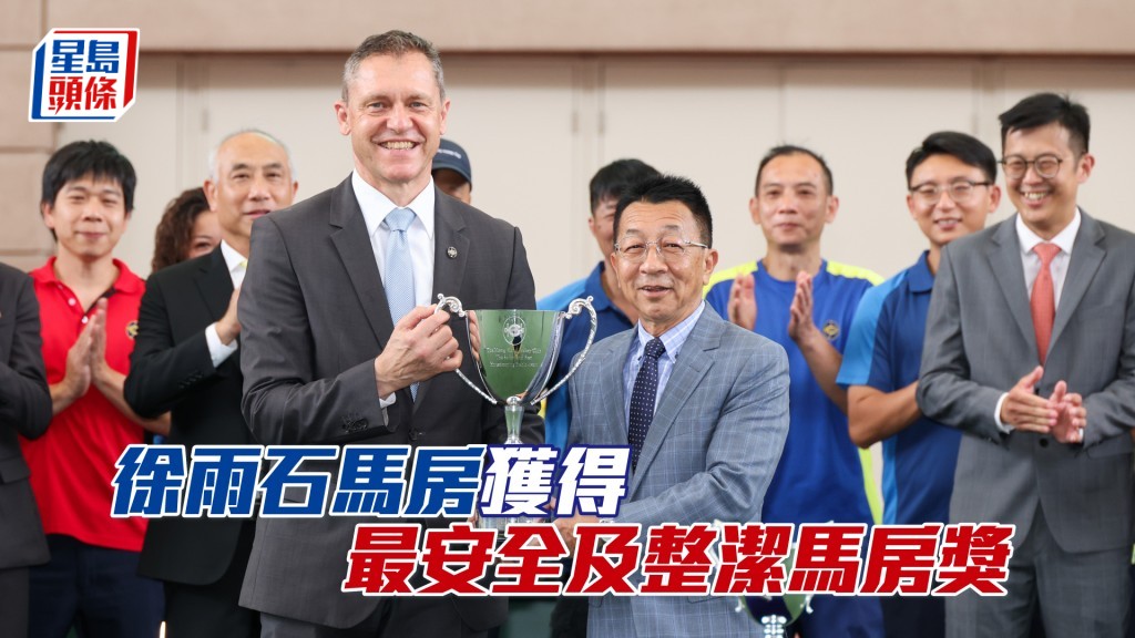 徐雨石馬房榮獲「最安全及整潔馬房獎」，香港賽馬會賽馬營運總監魏德（左）將獎座頒予練馬師徐雨石（右）。