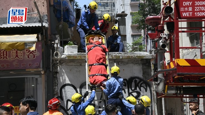 墮樓男子由消防員救下送院。楊偉亨攝