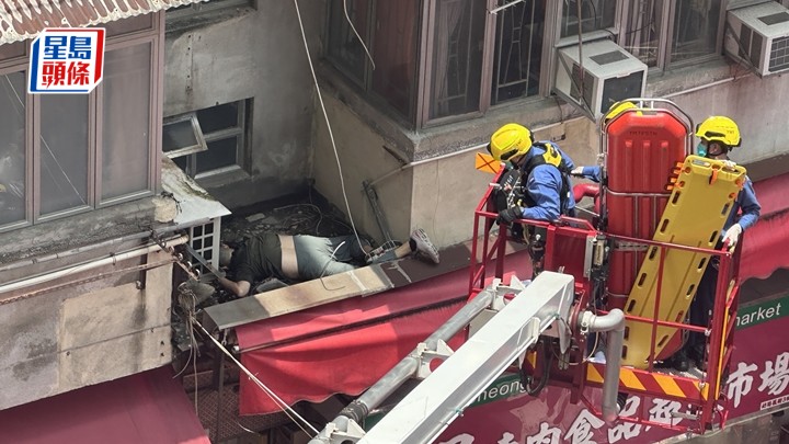 男子墮樓倒臥在大廈簷篷上，消防員升起雲梯救援。梁國峰攝