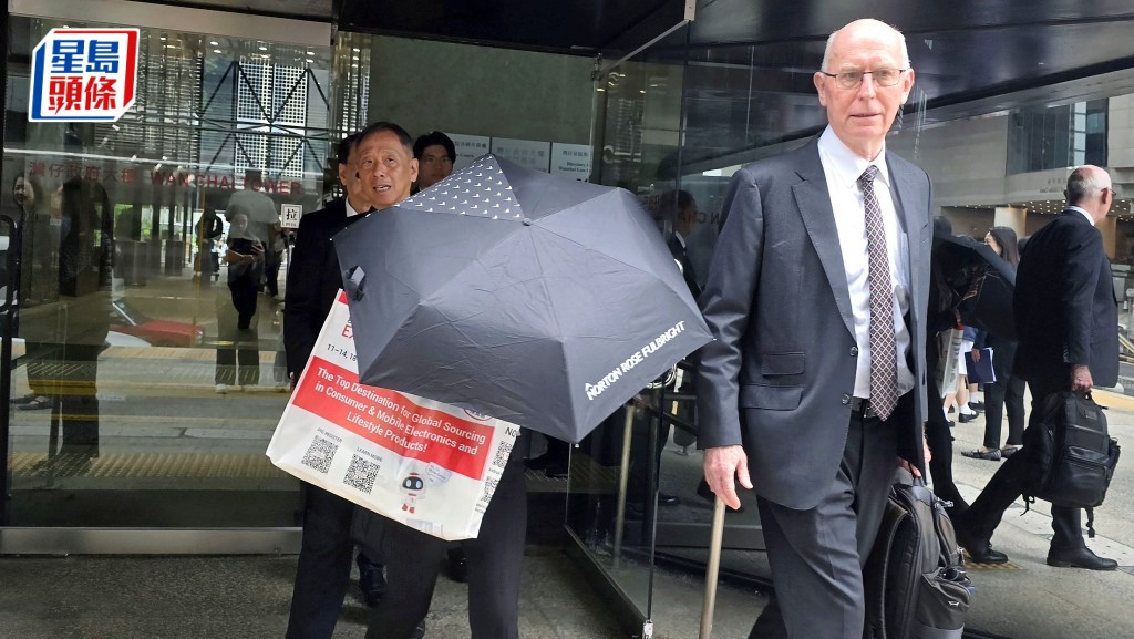 女被告王見菁（持黑傘女子）與代表大律師戴偉奧（右一）。王仁昌攝