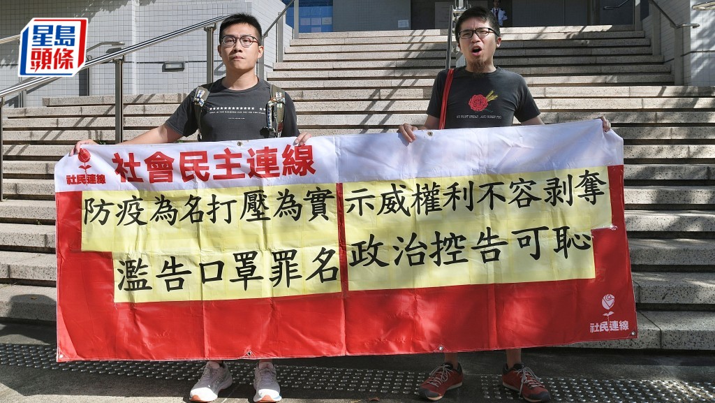 周嘉發(右)審訊前在庭外拉橫額投訴被票控屬政治打壓。陳浩元攝