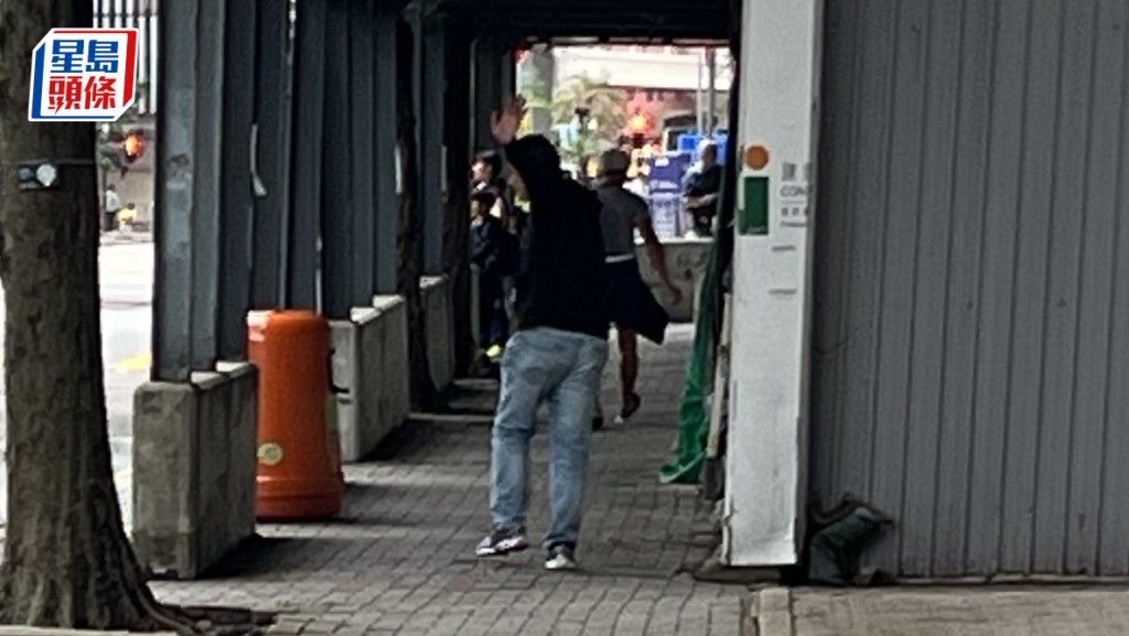 被告楊炳威（舉手者）離庭時拔足狂奔，跑離法庭一段距離才回眸睥睨記者。房伊媚攝