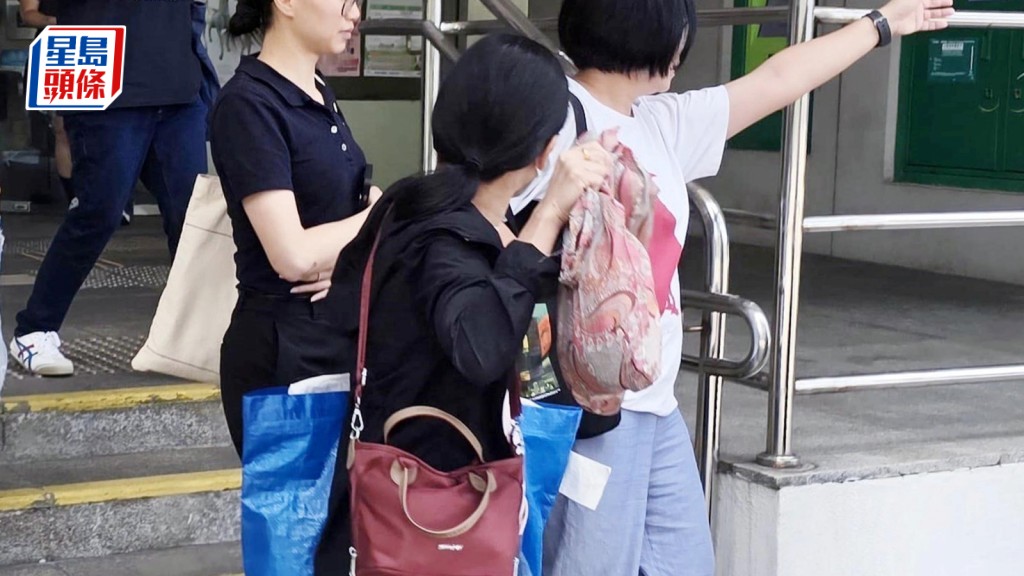 丁淑芬（持袋女子）被指向勞工處職員行賄，要求助申索工資。王仁昌攝