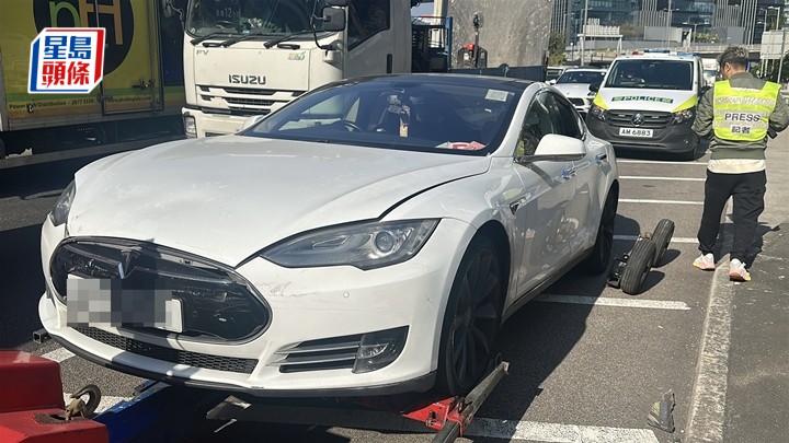 白色Tesla由拖車拖走，司機涉酒駕被捕。劉漢權攝