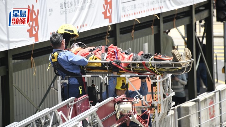 暈倒的工人由消防員用雲梯救下。楊偉亨攝