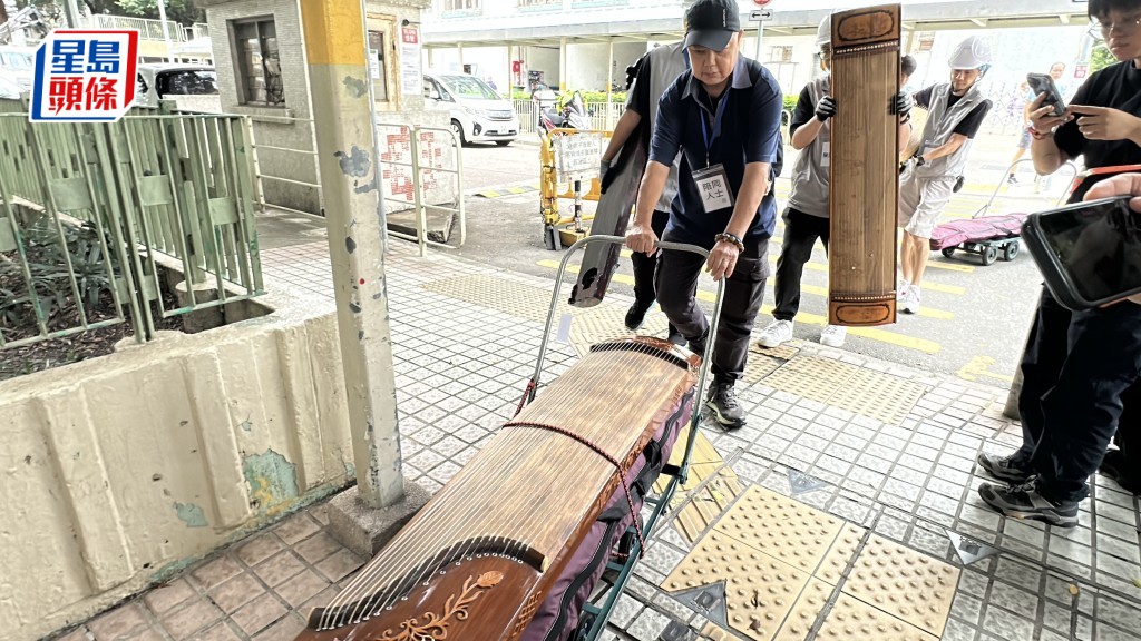 人员协助搬出古筝。刘汉权摄