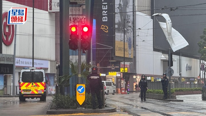 2米膠板掛在電車路的架空電纜上，警員在現場協助處理，以保人車安全。