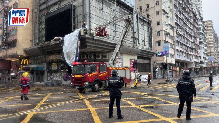 警方及消防到場清理塌下的巨型海報。梁國峰攝
