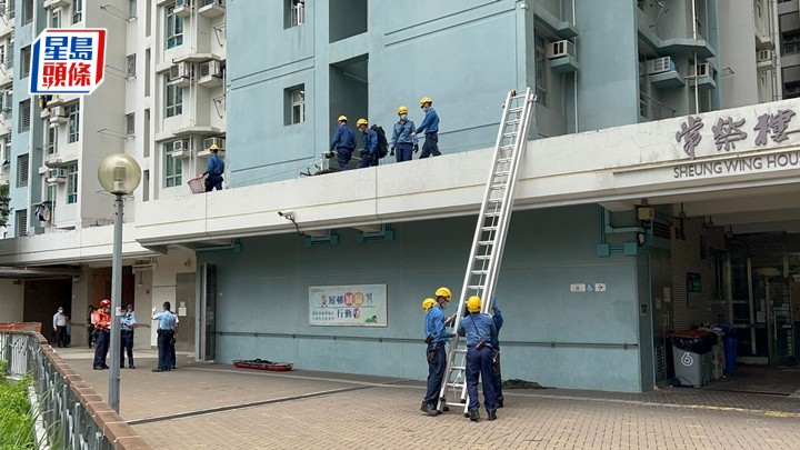 消防員出動鋼梯將遺體抬下。梁國峰攝