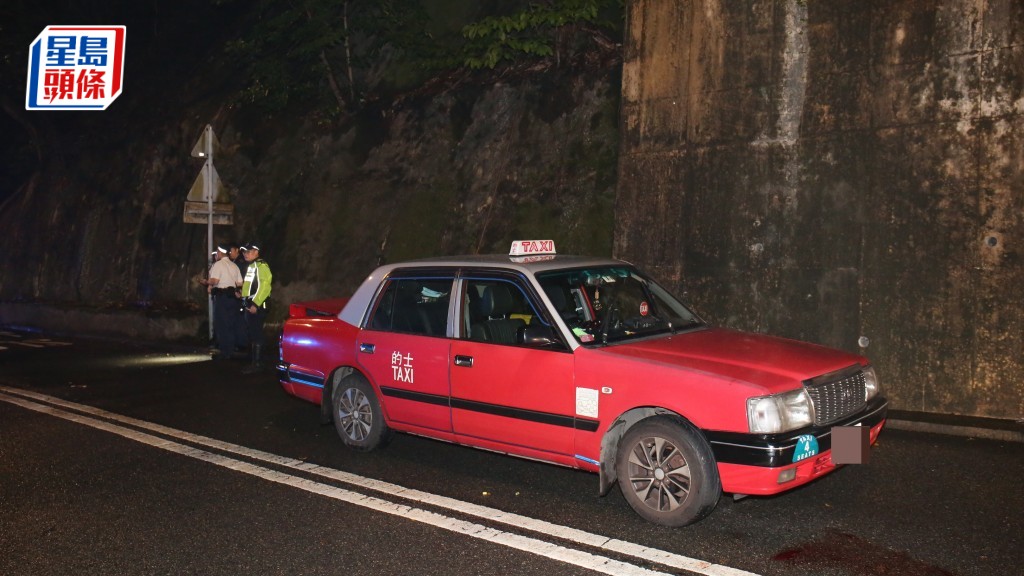 警員到場調查事件,的士車頭遺下一灘血跡。