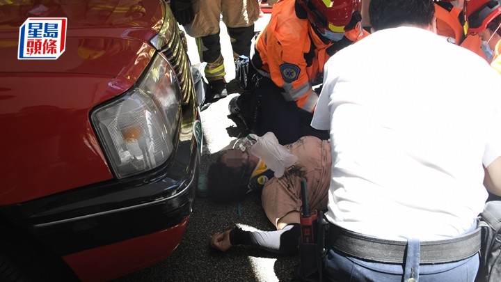 的士女司機捱撞被捲入行家的士車底，獲救出送院。楊偉亨攝