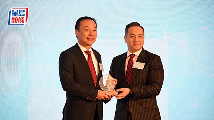 周一鳴（右）頒紀念品予嘉賓。楊偉亨攝