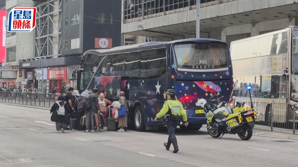 肇事旅遊巴案發後停於馬路中，警方到場調查。資料圖片