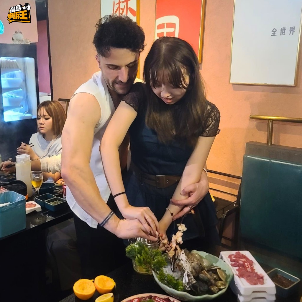 外籍猛男牽着女顧客的手,合力搾橙汁。 外籍猛男牽着女顧客的手,合力搾橙汁。