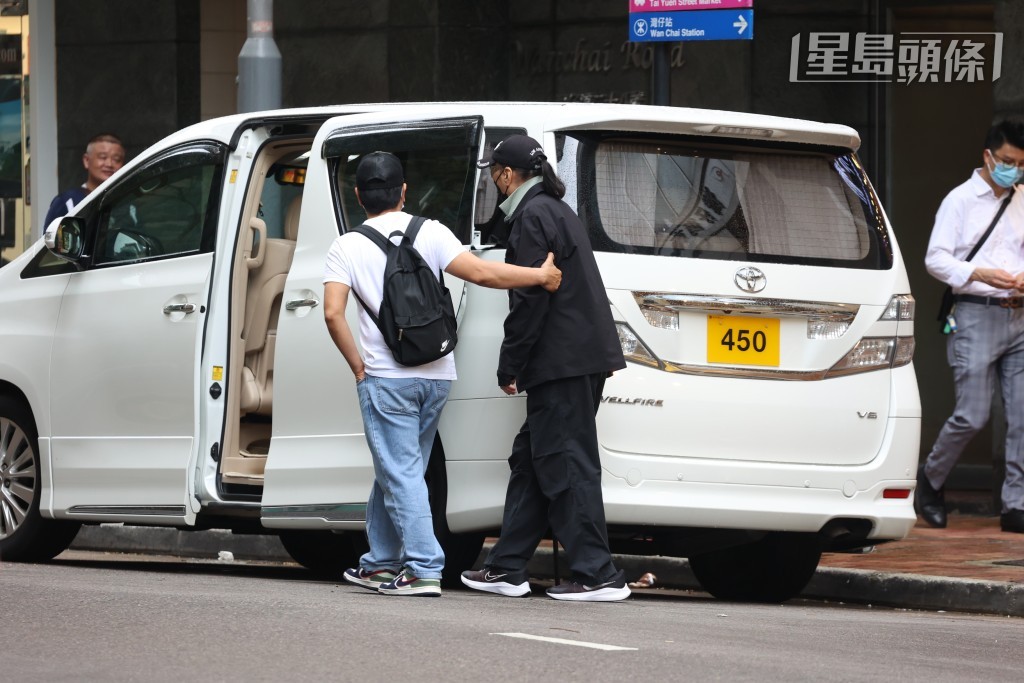 助手扶住他步上七人車，等侯工人買餸回來。