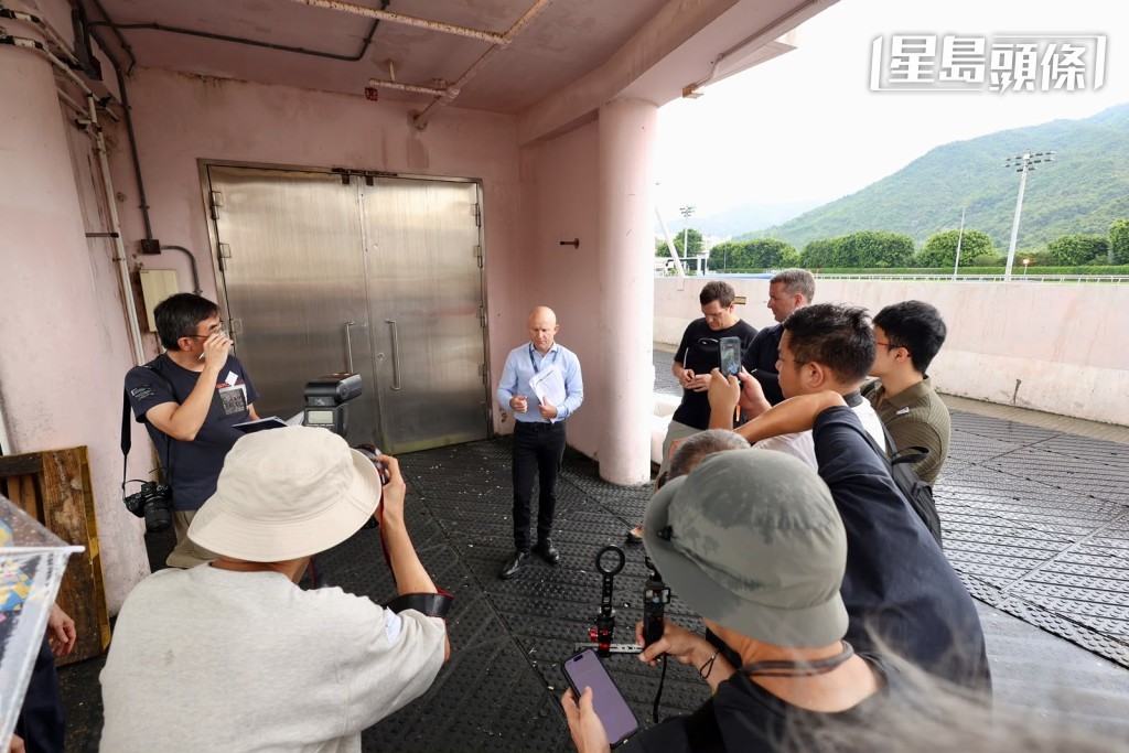 國際馬匹拍賣執行經理羅子達 (中) 帶領傳媒代表前往馬房，介紹將供競投的二十一匹拍賣馬。