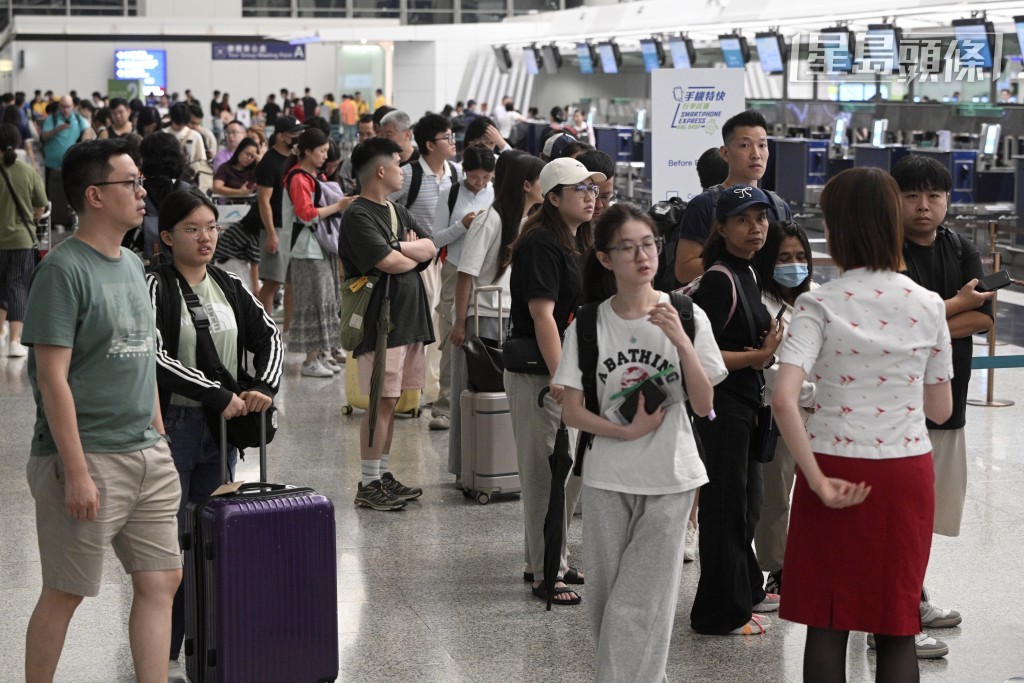 國泰航空客戶服務櫃位一度排起長龍，空姐在場協助旅客辦理手續。