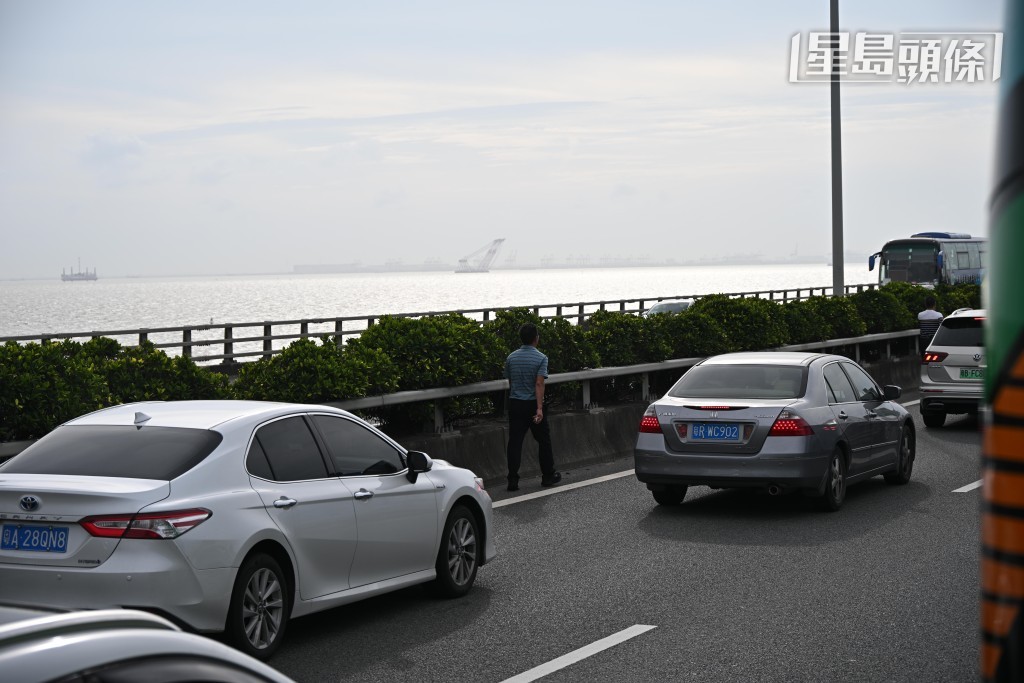 广深沿江高速公路有塞车情况，有人从私家车上下车步行。苏正谦摄