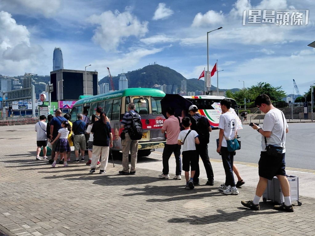 柯士甸站前往西九文化區的專線小巴有大批市民在烈日下大排長龍。周育瑩攝