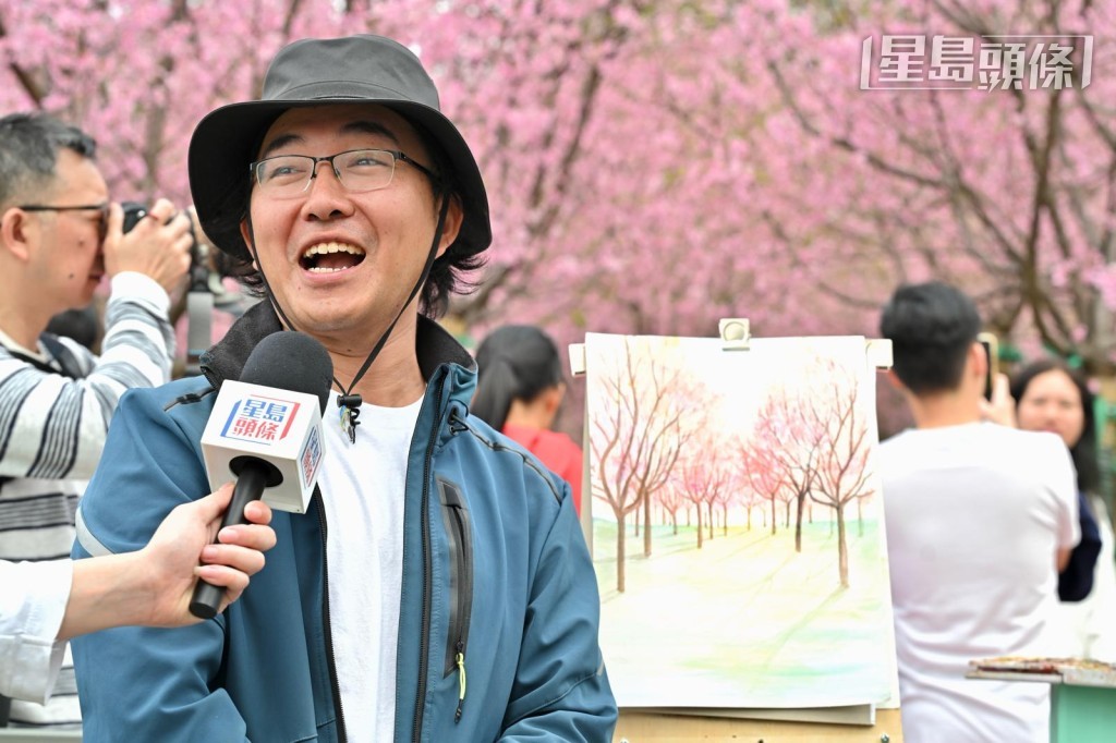 業餘畫家陳先生指今年花開比去年美很多。鍾健華攝 業餘畫家陳先生指今年花開比去年美很多。鍾健華攝