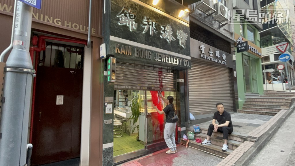 珠寶店負責人及職員清理油漆。