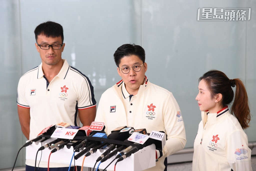 代表團團長霍啟剛，與兩名持旗手見記者。（何健勇攝）