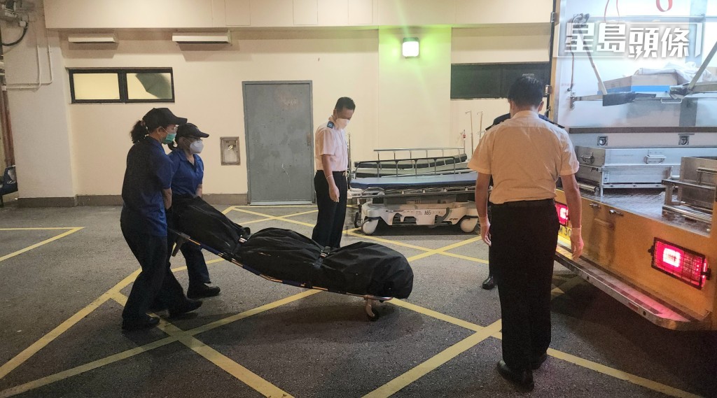 仵工将遗体移送至殓房，稍后交由法医检验。黄文威摄