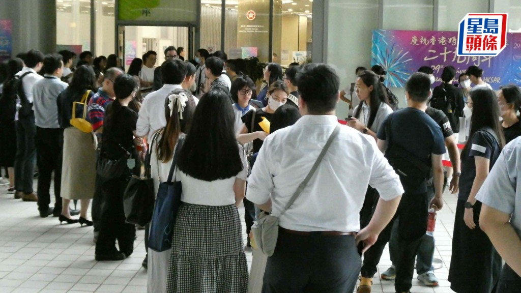 大批学校及老师代表聚集九龙塘的教育局教育服务中心学位分配组外，向内地家长招手。欧文瀚摄