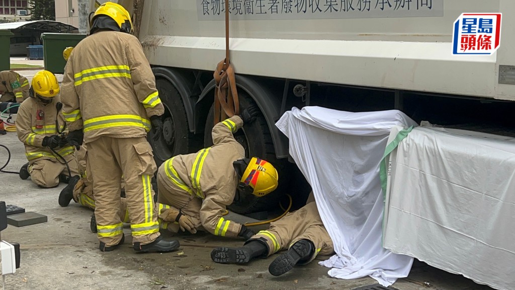 消防設法營救被困車底老婦。楊偉亨攝