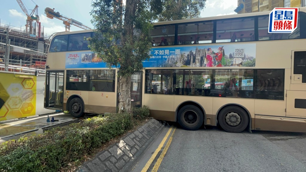 九巴直剷花槽險撞醫院地盤圍板。楊偉亨攝