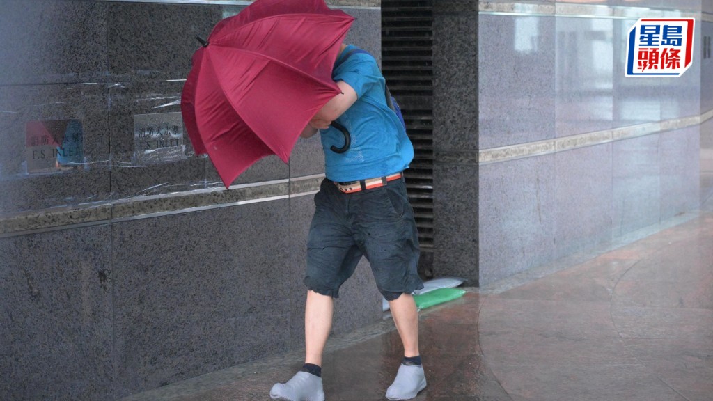 有市民冒雨前行。