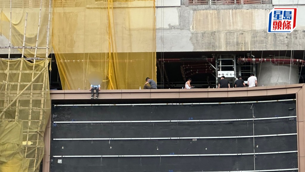 6名工人危坐5樓平台位置追討欠薪。讀者提供