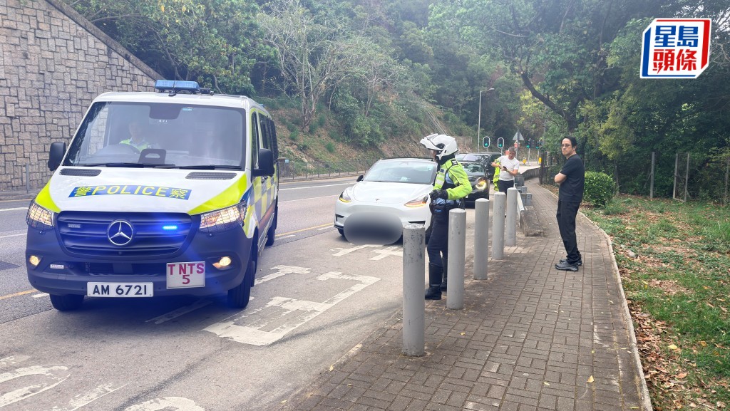 白色Tesla與電單車相撞，鐵騎士昏迷送院。圖右黑衫男子為私家車司機。梁國峰攝 