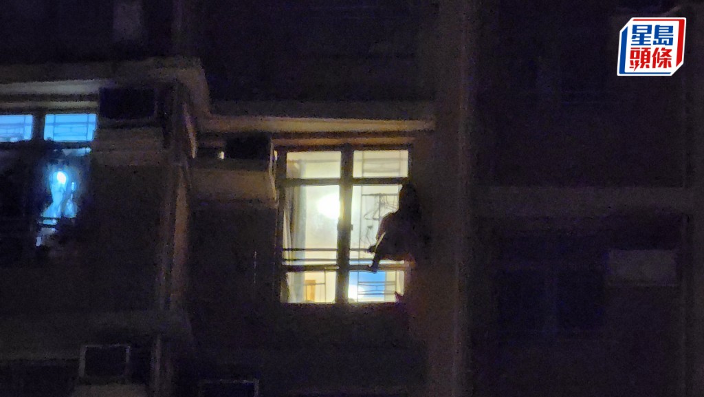 大圍美田邨一名女子危坐窗邊。黎志偉攝