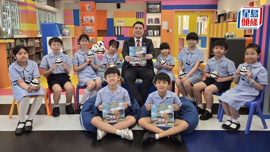 陳承邦與道教聯合會圓玄學院石圍角小學學生分享全新《大熊貓學習國安之旅》漫畫集。受訪者提供