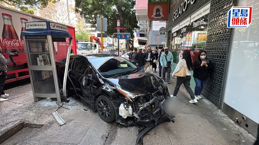 私家車鏟上行人路撞毀電話亭及郵筒。林思明攝