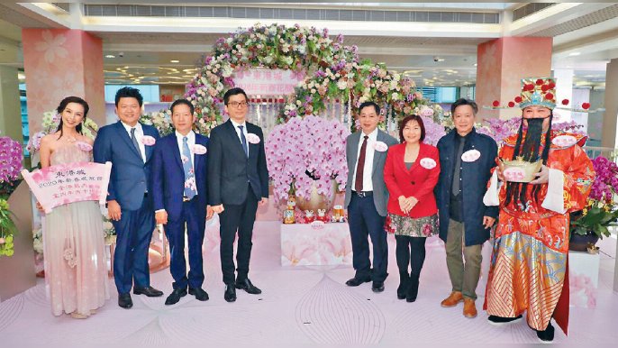 ■新地將軍澳旗艦商場東港城舉辦全港最大型室內年宵市場暨新春花展會。香港蘭花大王、千葉園始創人楊小龍（左三）、新一代蘭花才子楊尹俊（左二）、香港年花大王、香港鮮花盆栽批發商會主席賴榮春（右四），國際知名花藝大師區錦華（右二）開心合照。
