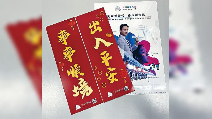 ■入境處職員向市民派發「自家製」揮春。
