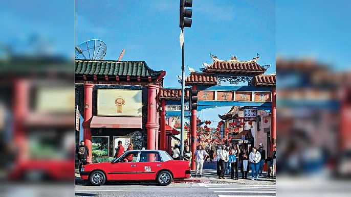 ■美國洛杉磯唐人街日前有一架紅色豐田Comfort房車出沒，後車門寫着「的士TAXI」。
